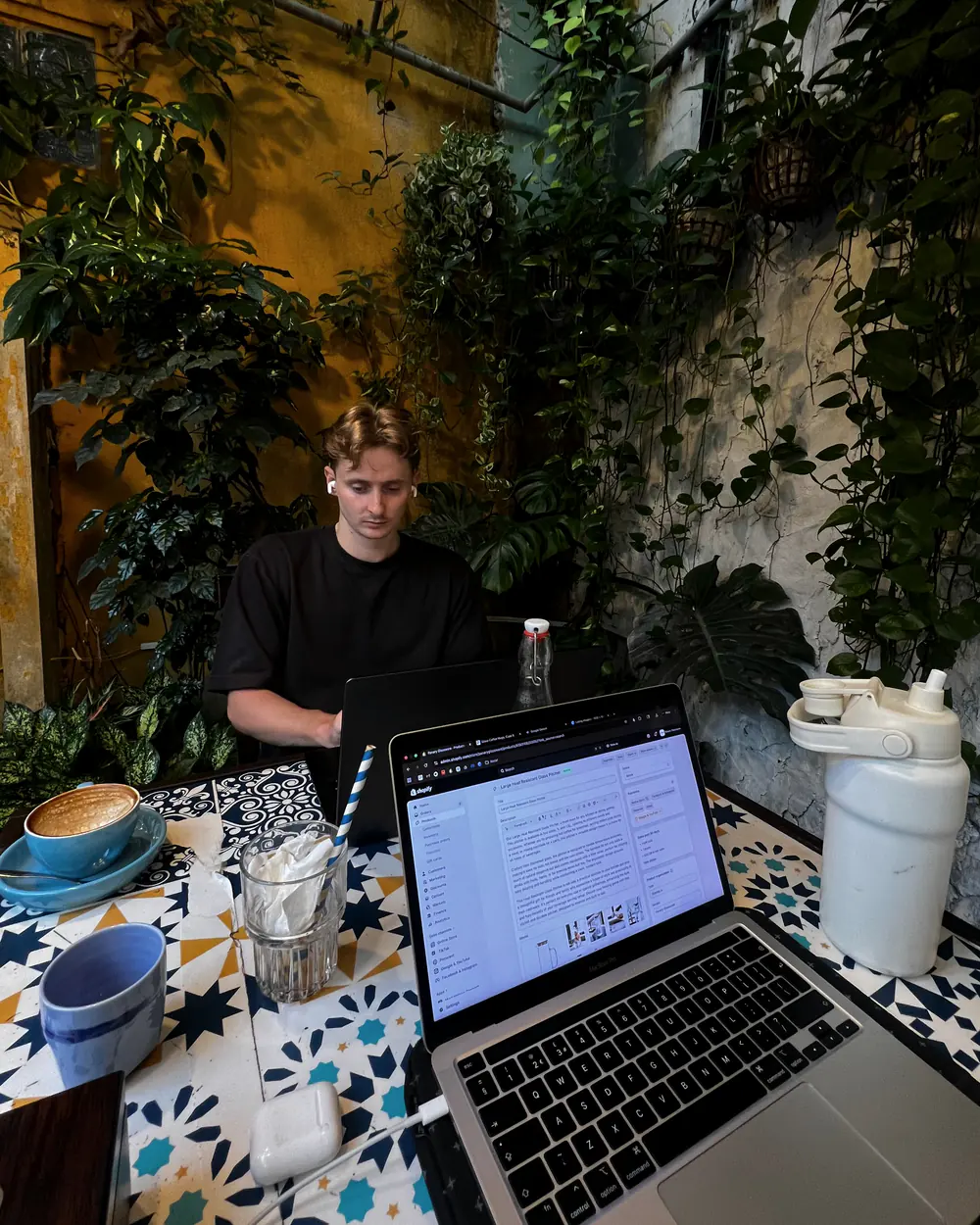 Jordan Macintyre at work on a Shopify store in a café